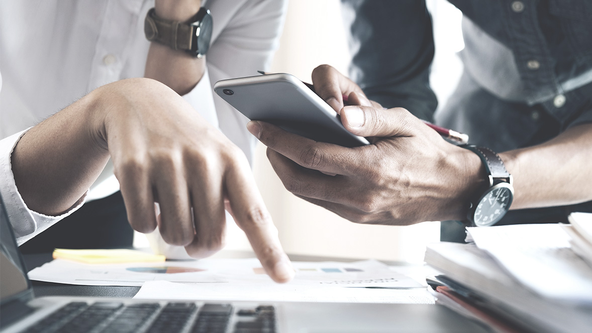 manos con papeles y celular